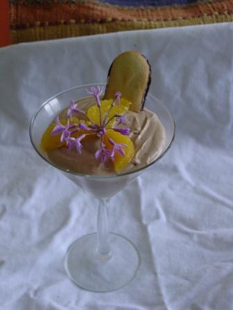 Chocolate mousse with citrus segments and flower garnish
